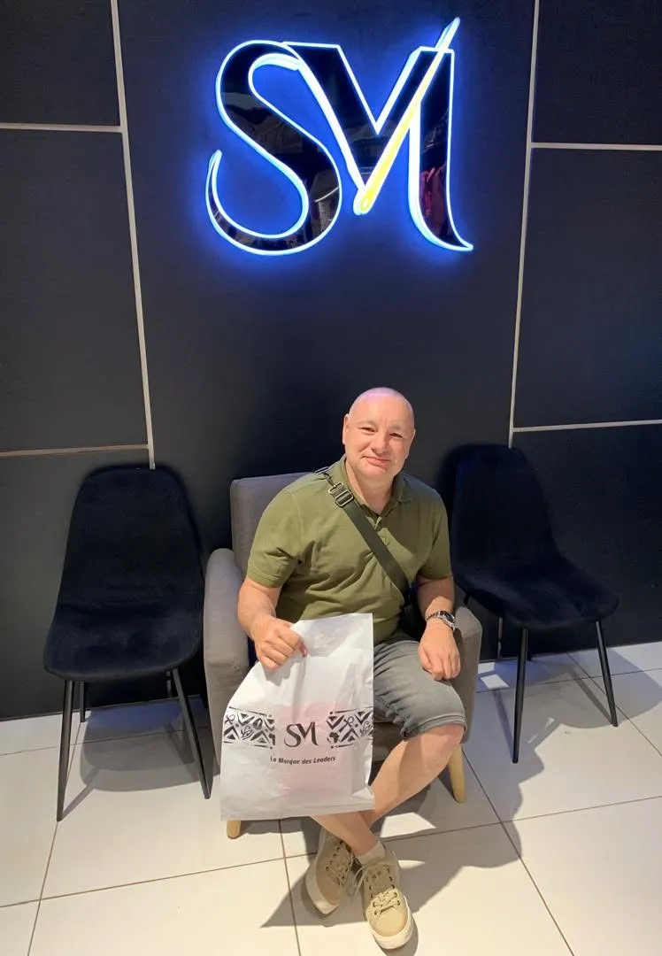 Client SurMesure avec son sac SM dans le showroom de Douala